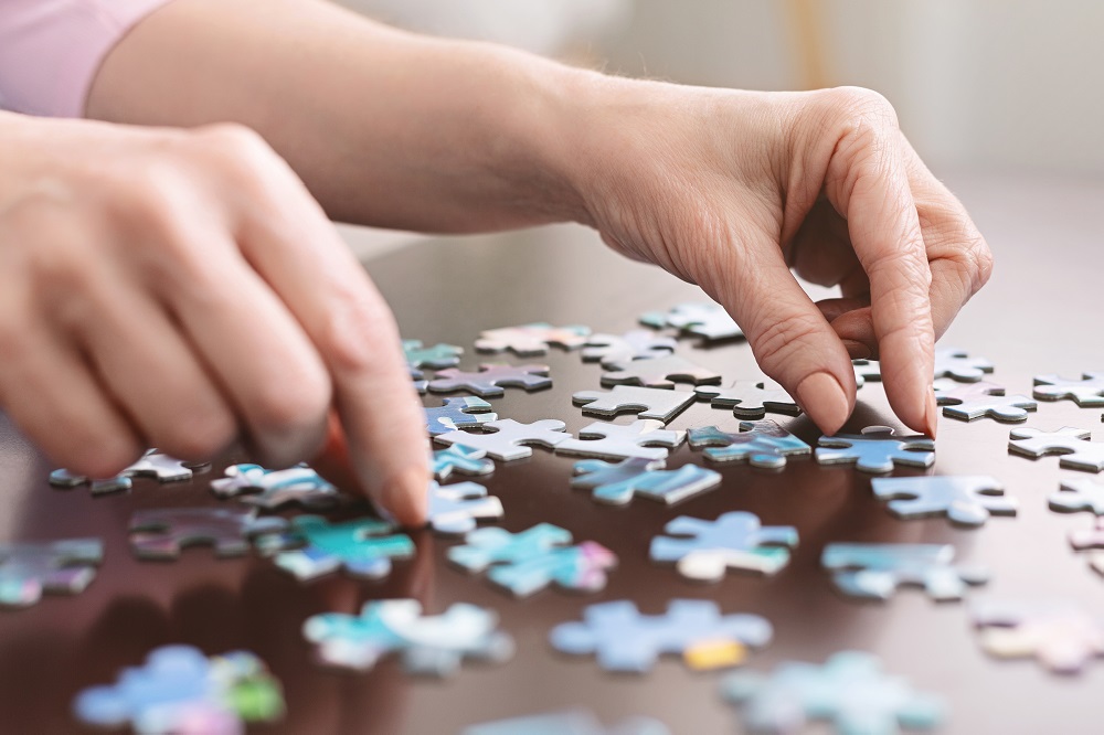 Female hands working on a puzzle for entertainment at Wellcome Manor